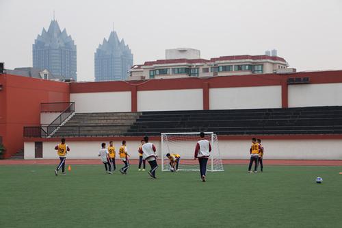 学生在教练的指导下踢足球
