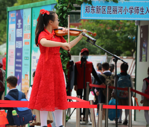 4.昆丽河小学学生刘豫卓，在校门口演奏《我爱你中国》