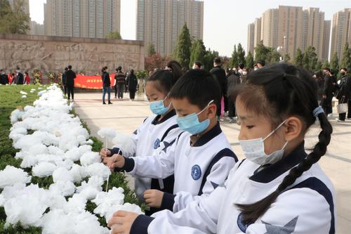 郑东新区龙腾小学学生向纪念碑敬献鲜花